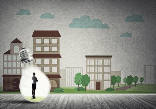 Businesswoman inside light bulb against city drawn concept