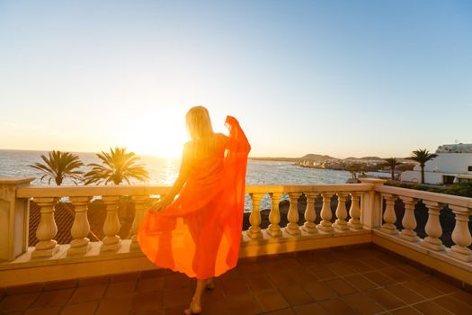 Woman looking on sea from balcony. Rear view