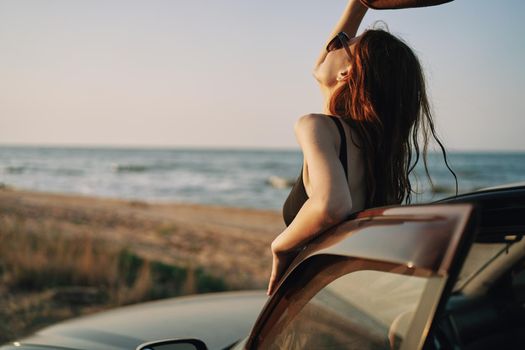 pretty woman in sunglasses near the car on the beach travel lifestyle. High quality photo