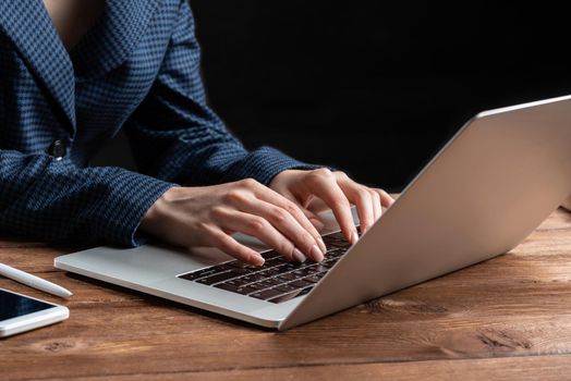 Business lady typing on laptop computer at wooden desk. Strategy planning and banking. Financial analyst working in office. Business accounting and project management. Close up woman hands on keyboard