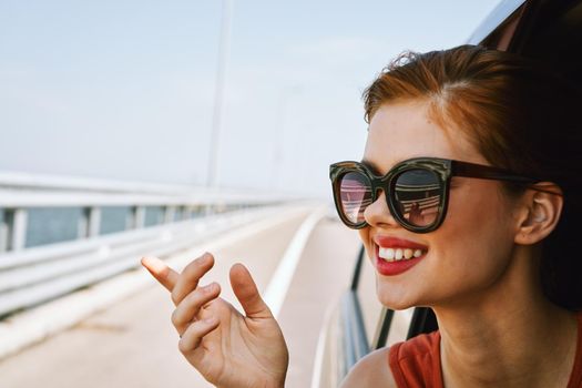 a woman is driving in a car on the road and looking out of the window. High quality photo