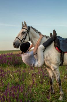 Beautiful young girl smile at her horse dressing uniform competition: outdoors portrait on sunset. Taking care of animals, love and friendship concept.