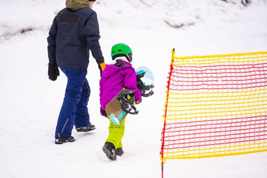 At Cold Winder Day at Mountain Ski Resort Father Teaching Little Daughter Snowboarding