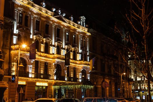 Lviv, Ukraine old town rynok market square alley in Lvov with winter Christmas illumination at night with snow.
