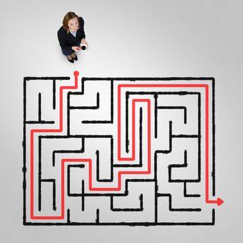 Top view of businesswoman with cup of coffee and drawn maze on floor