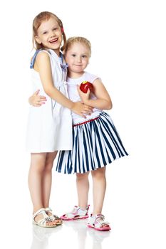 Two cute little girls with apples, in the studio on a white background. Concept of happy childhood, healthy eating. Isolated.