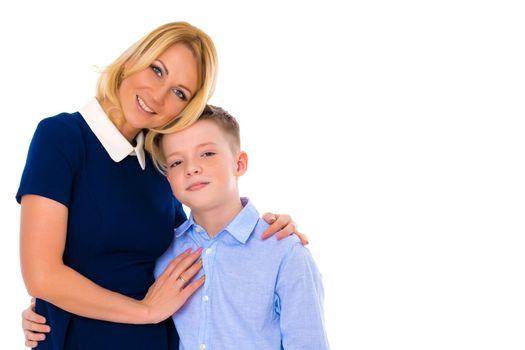 Happy young mother with her son of school age in the studio on a white background. The concept of family values, the upbringing of children. Isolated.