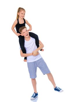 Charming little girl hugging a tall boy with blond hair. A romantic couple is happy with the joint time brought. A happy sister hugs her brother. The concept is a happy childhood. Isolated on white background.