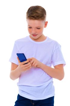 A small boy of school age uses a mobile phone. The concept of digital technology, communication between people. Isolated on white background.