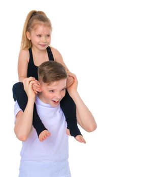 Charming little girl hugging a tall boy with blond hair. A romantic couple is happy with the joint time brought. A happy sister hugs her brother. The concept is a happy childhood. Isolated on white background.