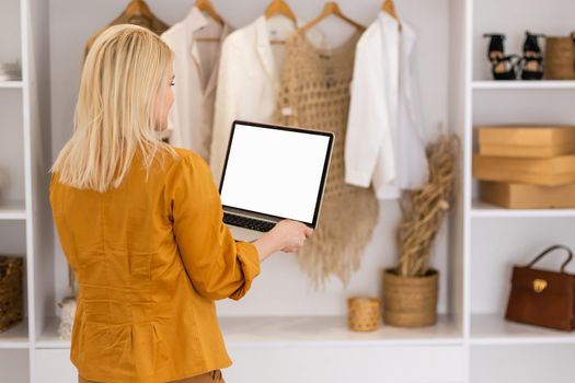 Rear view of business woman hands busy using laptop at office desk, with copyspace.