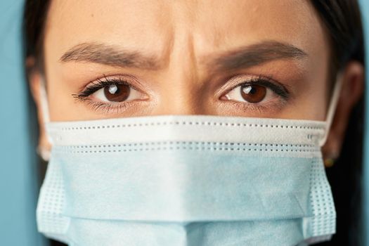 Close up of upset lady in a face mask from viruses during a pandemic. Quarantine, coronavirus concept