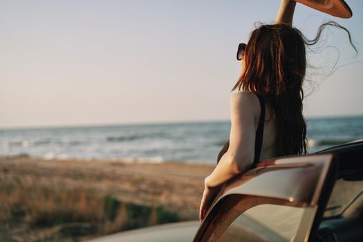 pretty woman in sunglasses near the car on the beach travel lifestyle. High quality photo