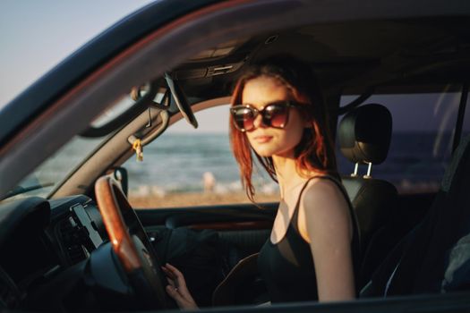 cheerful woman in sunglasses driving a car trip travel. High quality photo