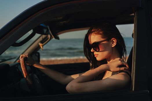 cheerful woman in sunglasses driving a car trip travel. High quality photo