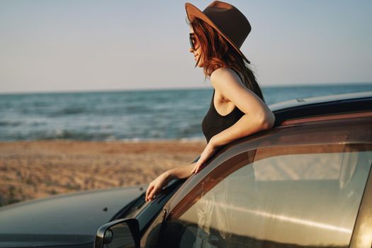 pretty woman in sunglasses near the car on the beach travel lifestyle. High quality photo