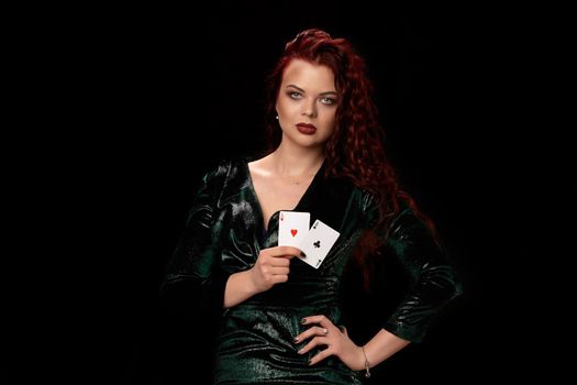 Sexy redheaded woman in a leather black dress with a playing cards over black. Win casino holdem poker slots