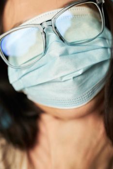 Cropped photo of female face with a protective mask and glasses on her eyes. Quarantine, epidemic concept