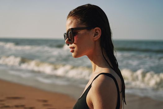 Cheerful woman black swimsuit ocean nature summer tan. High quality photo