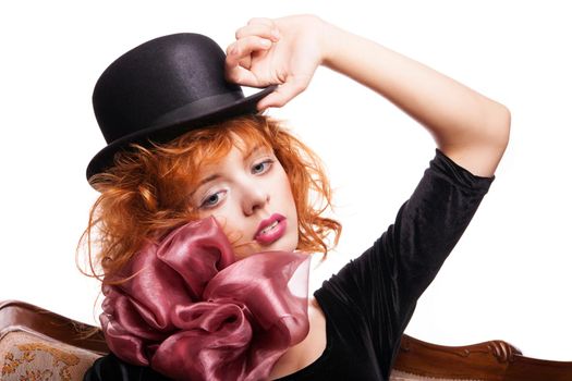 Girl with beautiful red hair, pink bow and black dress over white background