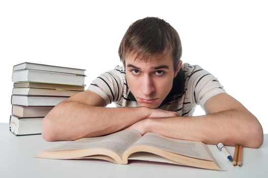 Male student at the table with a pile of books over white