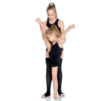 Lovely little girls gymnasts warm up before the competition. The concept of a happy childhood, sports and fitness. Isolated on white background.