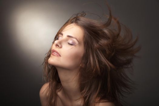 Sensual young woman with beautiful long brown hairs, posing. Studio shot