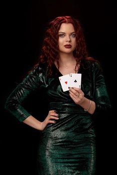 Charming redheaded woman with curly hair and a playing cards in her hands over black. Win casino holdem poker slots