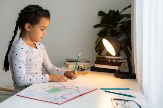 children, education and learning concept - student girl with book writing to notebook at home