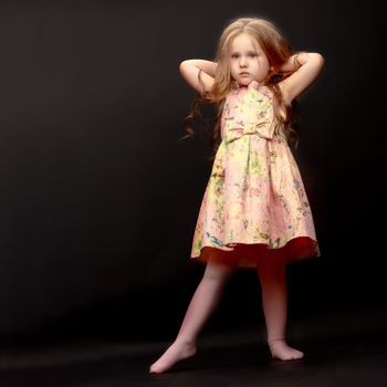 Beautiful little girl on a black background. Studio photography