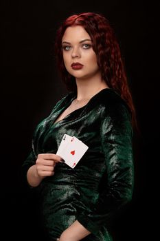 Beautiful redheaded woman with a playing cards in her arms turned sideways over black. Win casino poker slots
