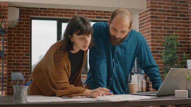 Man and woman doing teamwork to design project strategy and research analysis for presentation. Colleagues working together to plan marketing development with rate charts papers.