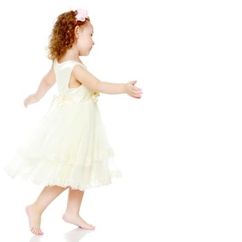 A little girl is jumping and waving her hands. The concept of a happy childhood, outdoor recreation. Isolated on white background.