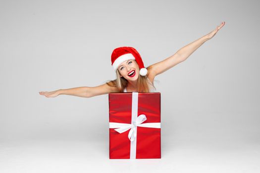 funny caucasian woman portray an airplane with a big red box with gift