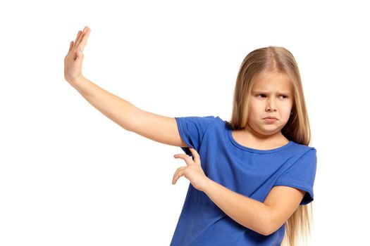 Portrait of adorable little girl isolated on a white background. in blue t-short with long white hair, pushing something away