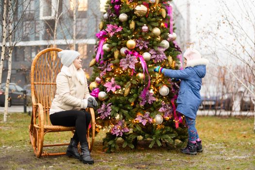 woman and photo zone christmas tree and rocking chair on the street