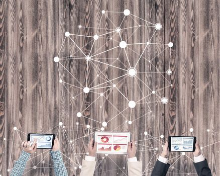 Group of three people with devices in hands working together as symbol of networking and communication