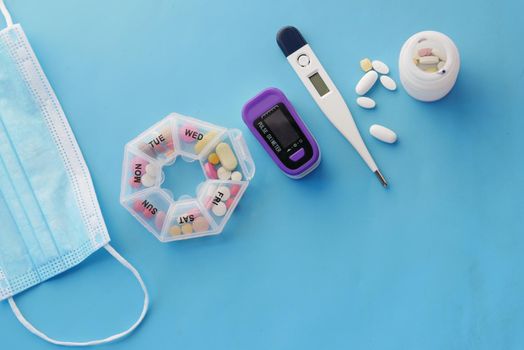 Surgical masks, thermometer and thermometer on blue .