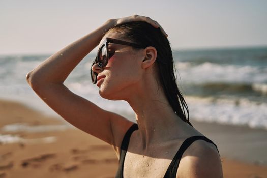 Cheerful woman black swimsuit ocean nature summer tan. High quality photo