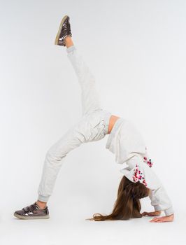 Young girl doing bridge position on the one leg support, one leg extended upwards