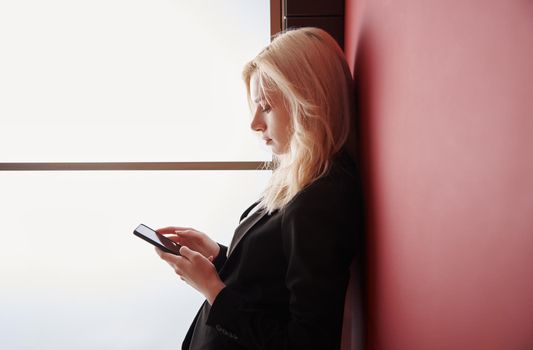 Young adult woman using smartphone at the office