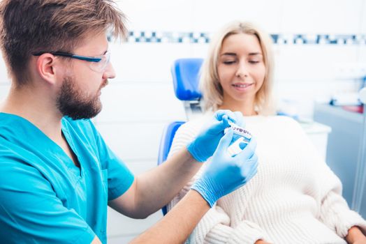 Dentist showing patient teeth model