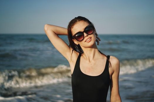 cheerful woman in black swimsuit sunglasses ocean travel. High quality photo