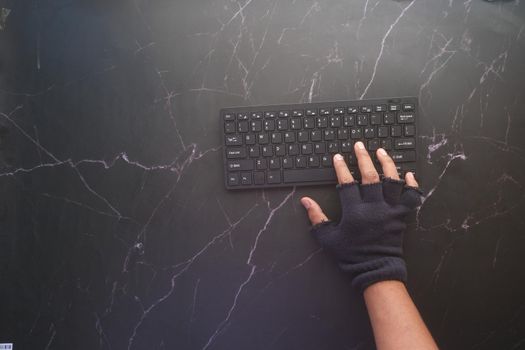 hacker hand stealing data from laptop top down.