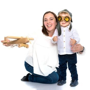 Mom and son are playing with a toy wooden plane. The concept of a happy childhood, raising a child in the family. Isolated on white background.