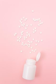 Global Pharmaceutical Industry and Medicinal Products - White Pills or Tablets Scattered from the Pill Container, Lying on Pink Background