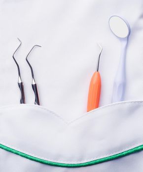 Closeup of dental tools in white medical uniform pocket
