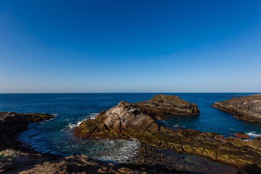 Tropical island of Tenerife. The coast of a Spanish city on the Atlantic ocean. Panorama of the city and beach on the island of Tenerife. Background color with gradient and grain, sound effect.
