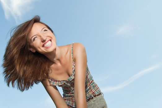 Portrait of a beautiful young woman smiling against the sky - Outdoor