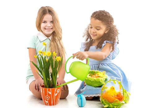 easter concept. two little smiling girls watering flowers and playing on the floor isolated on white background